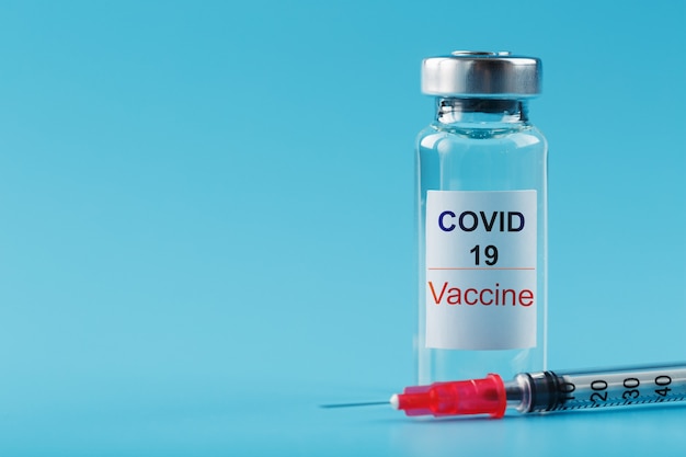 病気に対するCovid-19ウイルスに対するワクチンを接種した注射器とアンプル