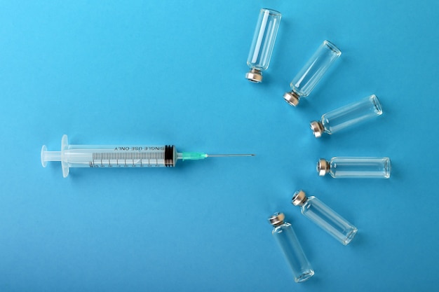 syringe and ampoules on blue background