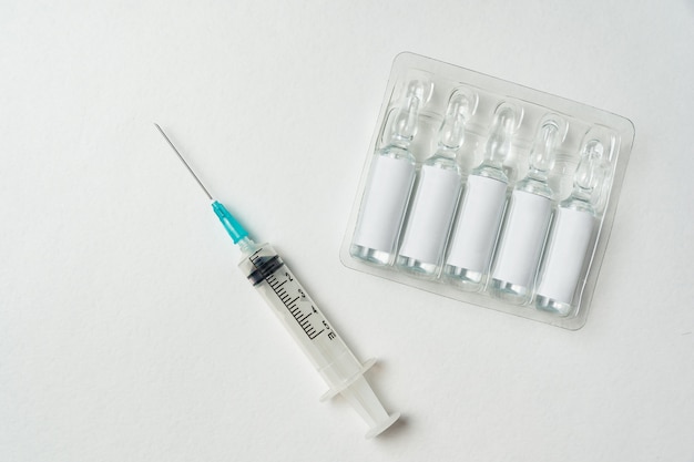 Syringe and ampoules with blank label on white background.