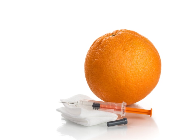 Syringe, gauze and orange on white background