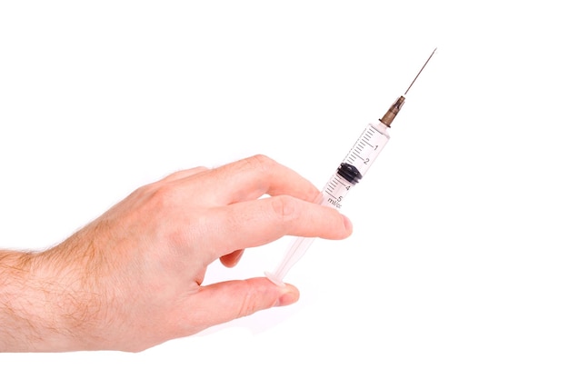 Syringe in hand on white background closeup