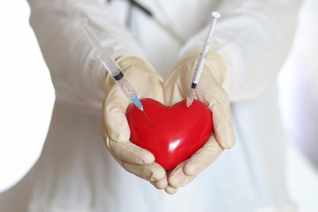 Photo syringe in heart holding doctors hand concept