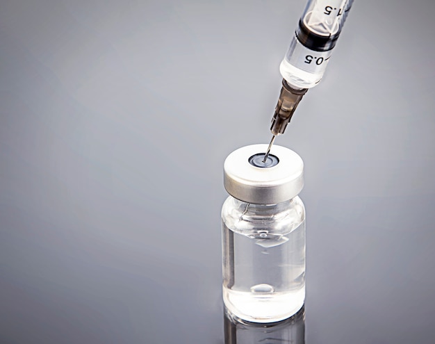 Photo a syringe inserted into an ampoule for injection