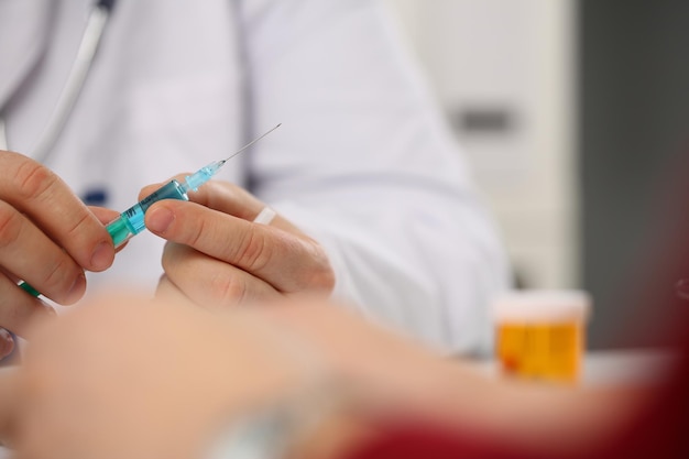 Syringe and medical injection in doctor hand closeup