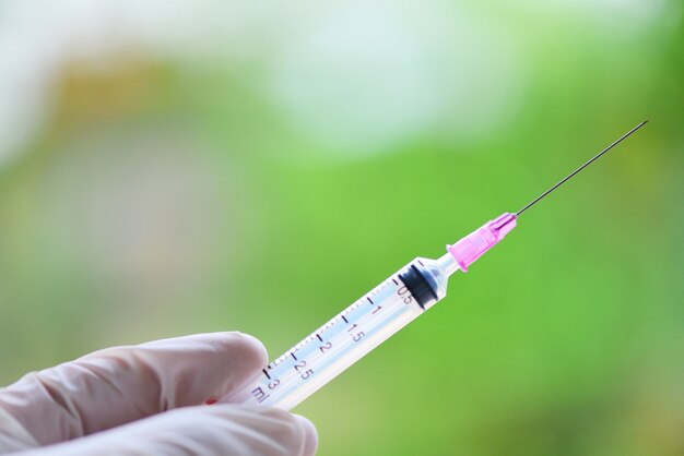 Syringe medication injection and needle in hand nurse for giving patient vaccine prophylactic 