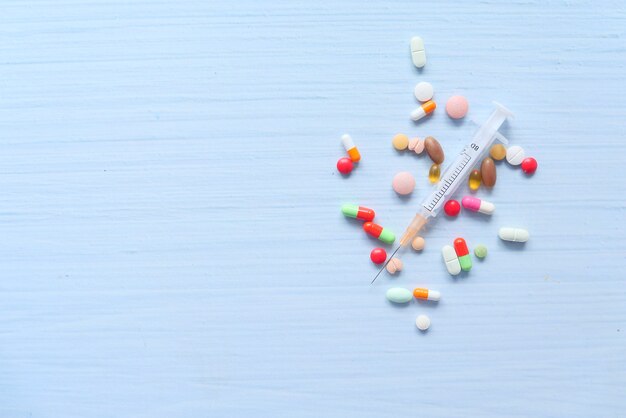 syringe and pills on white space, top view