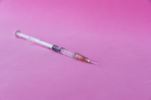 Photo syringe of pink background. colorful concept .creative minimal medicinal background.