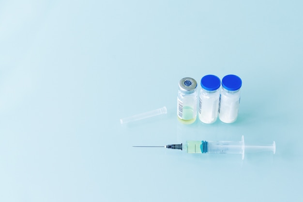 Syringe and three vials of vaccine