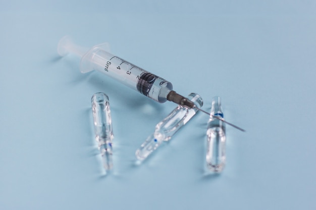 Syringe with ampoules on a blue vaccination