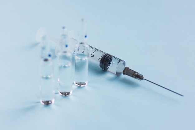 Syringe with ampoules on a blue vaccination