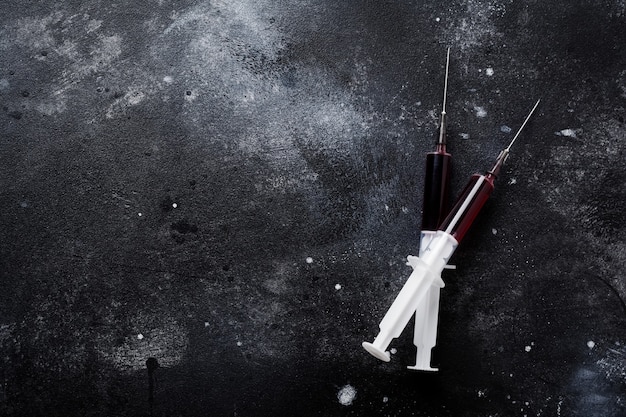 Syringe with blood on old concrete surface