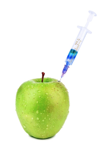 Syringe with blue vaccine in green apple on white background