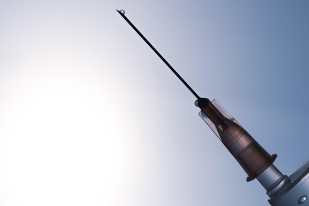 a syringe with a clear blue sky in the background