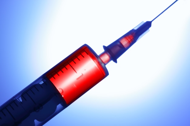 Syringe with red drug closeup. Shallow DOF!