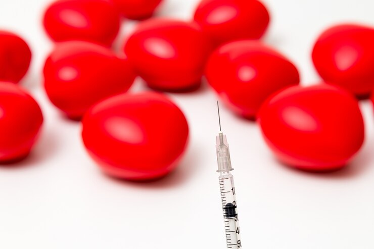 Photo syringe with red heart . isolated on white background. studio lighting. concept for healthy and medi