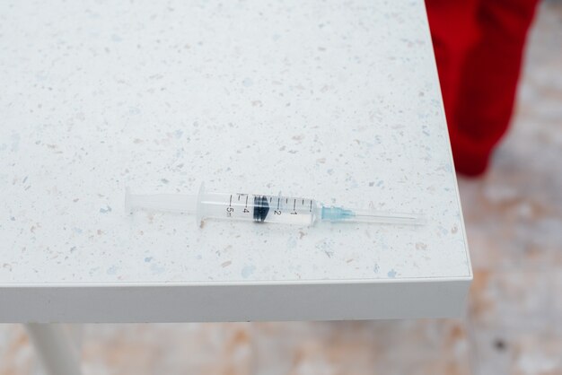 The syringe with the vaccine is on the table