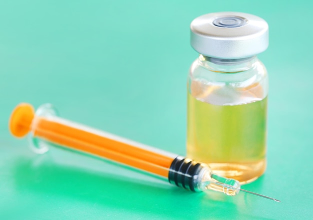 Photo syringe with vial on green surface