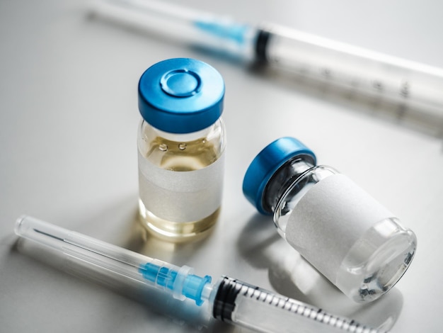 Syringes, injection bottles and tablets lying on the table