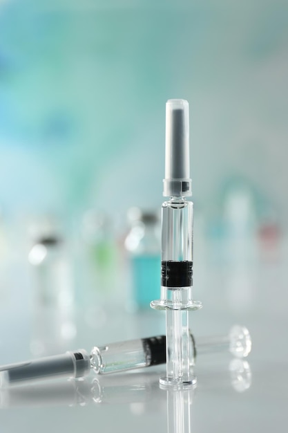 Syringes with COVID19 vaccine on white table