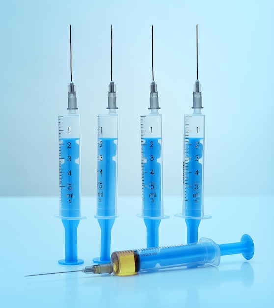 Syringes with medicine on blue background