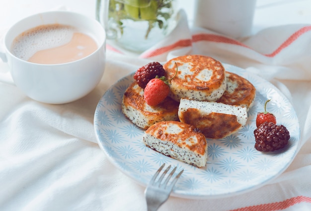 Photo syrniki with berries on a plate