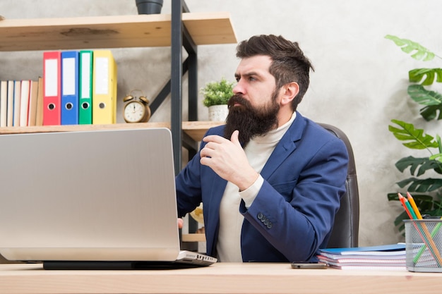 Systeembeheerder onderhoud server rack configuratie van computersystemen en netwerken brutale man in kantoor volwassen man hipster gebruik computer mannelijke baas werken sysadmin dag 28 juli