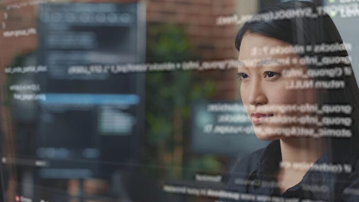 Photo system administrator being helped by ar hologram to visualize script, writing code on computer screen while in office using programming language. expert fixing errors during server maintenance