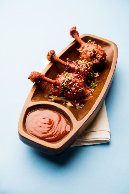 Szechuan Chicken which is a popular Indo-Chinese non vegetarian recipe. served in a plate with chilli sauce. selective focus