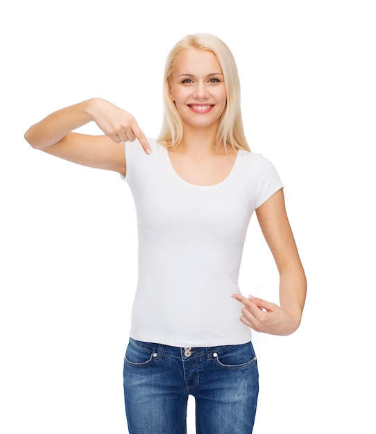 t-shirt design concept - smiling young woman pointing finger to blank white t-shirt