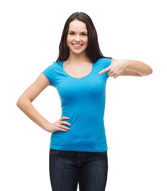 t-shirt design and gesture concept - smiling girl in blank blue t-shirt pointing her finger at herself