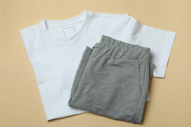 T-shirt and sweatpants on beige, top view