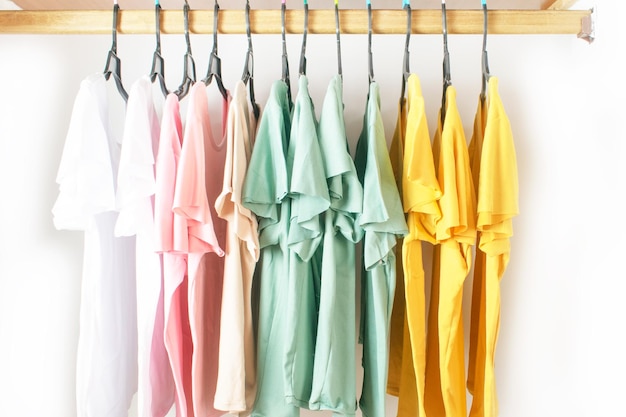 T-shirts in basic kleuren opgehangen aan haken in de kast