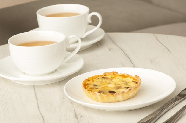 Taart en twee kopjes koffie op een tafel met bestek