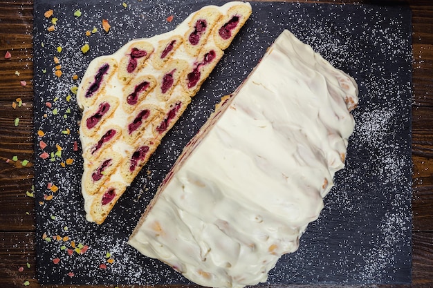 Taart met room en kersen en kopje koffiesmakelijke cake met witte roomRussische cake genaamd Monastyrskaya izba kloosterhut met kersen