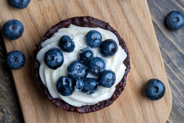 Taartje met room en bosbessensmaak zoet dessert met room en rijpe bosbessen