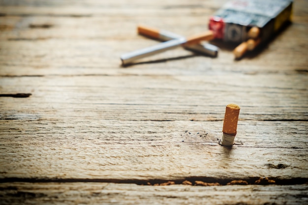 Tabak in de sigaret, liggend op een houten tafel.