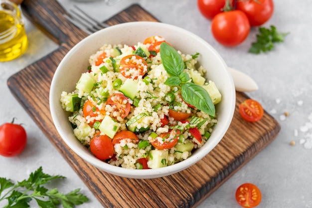 Tabbouleh salad Couscous salad with fresh vegetables and herbs in a bowl Copy space