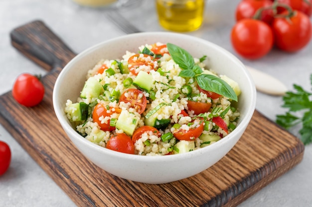 Tabbouleh salad Couscous salad with fresh vegetables and herbs in a bowl Copy space