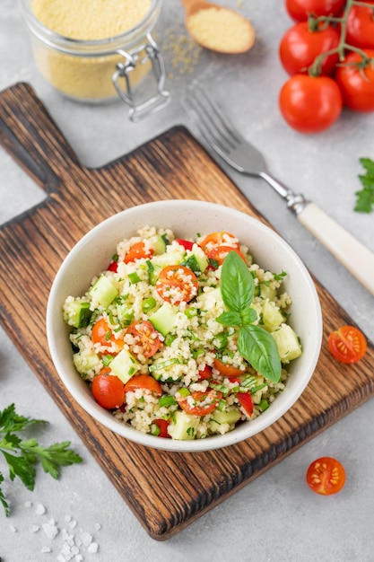 Tabbouleh salad Couscous salad with fresh vegetables and herbs in a bowl  Copy space