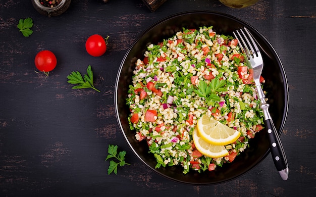 Tabbouleh salad. Traditional middle eastern or arab dish. Levantine vegetarian salad with parsley, mint, bulgur, tomato.