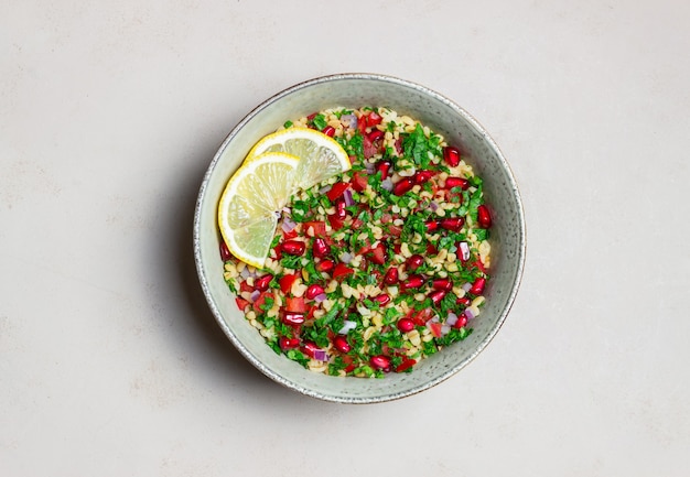 Tabbouleh salad with bulgur, mint, parsley, tomatoes and pomegranate. Healthy eating. Vegetarian food.