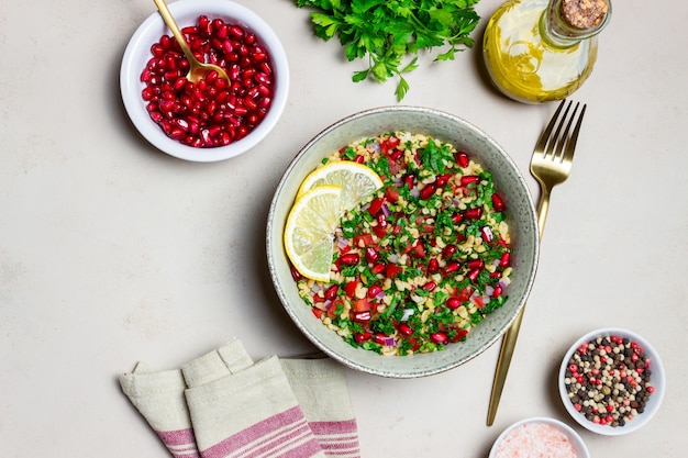 bulgur, 민트, 파슬리, 토마토, 석류를 곁들인 타불레 샐러드. 건강한 식생활. 채식주의 자 음식.