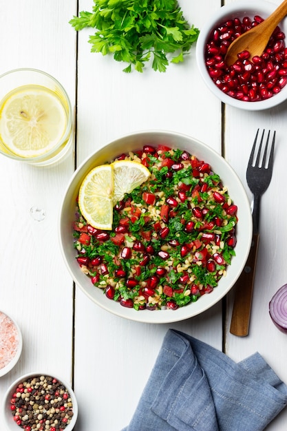 bulgur, 민트, 파슬리, 토마토, 석류를 곁들인 타불레 샐러드. 건강한 식생활. 채식주의 자 음식.