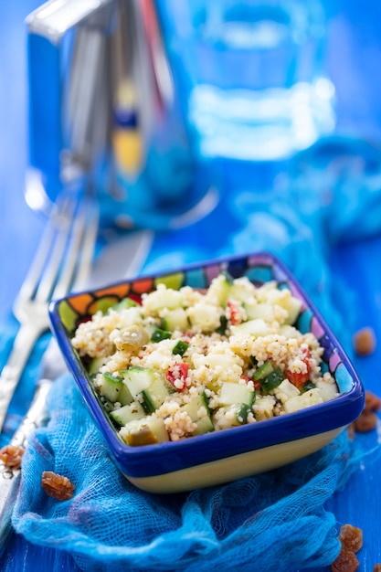 Tabbouleh in small bowl on ceramic background