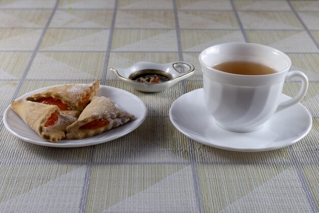 On the table are a cup of tea and cookies.