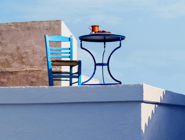 Table blue chair and a jug of wine for relaxing at noon in the Greek Islands Skopelos in Greece