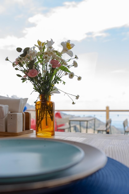 a table in a cafe with blue plates and flowers on the table