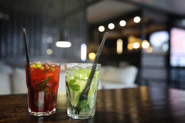 A table in a cafe with a cocktail and a cup of tea