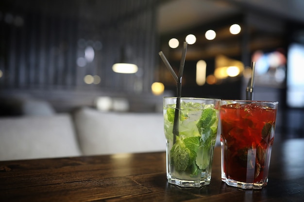 A table in a cafe with a cocktail and a cup of tea