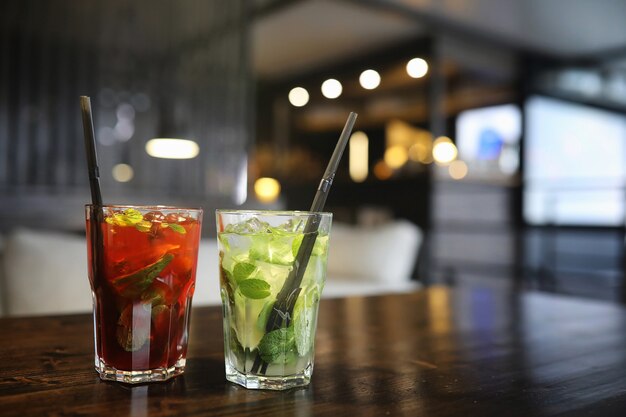 A table in a cafe with a cocktail and a cup of tea